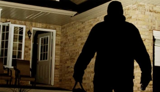 Un ladro si avvicina di notte a una abitazione