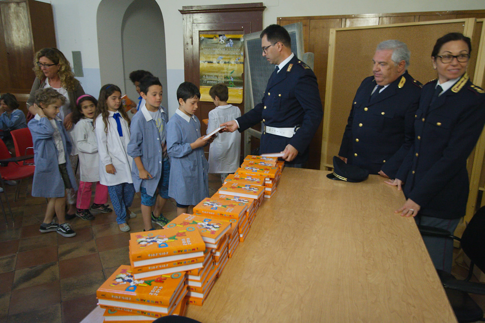 I poliziotti della questura di Ravenna mentre consegnano i diari ai bambini.