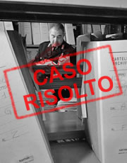 Timbro caso risolto e sullo sfondo un operatore di polizia consulta vecchi fascicoli di un archivio