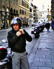 Giovane motociclista mentre allaccia il casco
