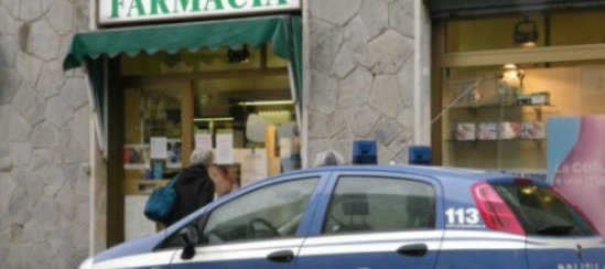 volante della polizia davanti a una farmacia