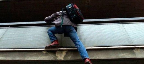 Un ladro che si arrampica su un balcone